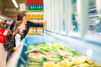 Mother and daughter in supermarket near frozen food