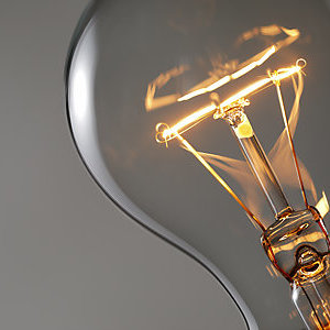Close-up of a light bulb with its filament glowing.
