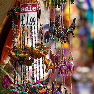 Close-up of sale price tag for beaded necklaces and other trinkets on a vendor’s stall at Camden Market, London.